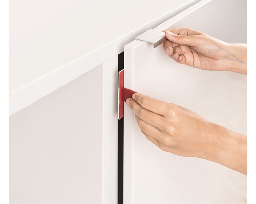 Une personne fixe un verrou d''armoire à une porte d''armoire.