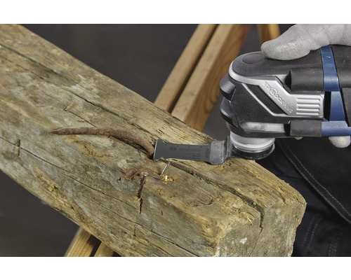 Outil multifonction lors du traitement d''une poutre en bois avec des clous.