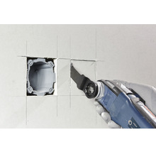 Outil électrique oscillant découpant une ouverture dans un mur pour une boîte d''appareil