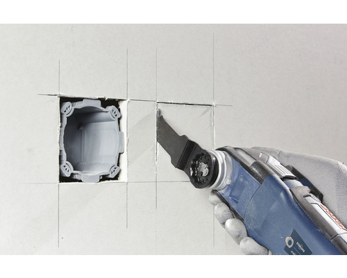 Outil électrique oscillant découpant une ouverture dans un mur pour une boîte d''appareil
