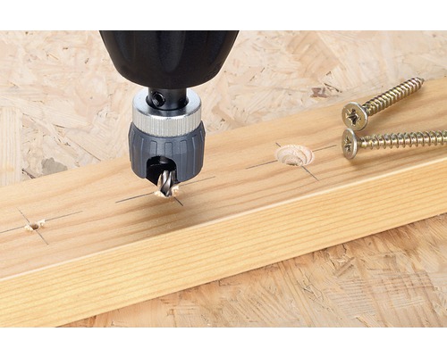 Senkkopfbohrer im Einsatz auf einem Holzbrett neben Schrauben