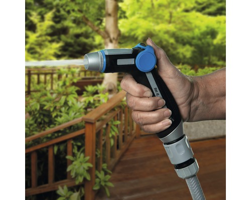 Une personne tient une tête de pulvérisation de jardin d''où sort de l''eau.