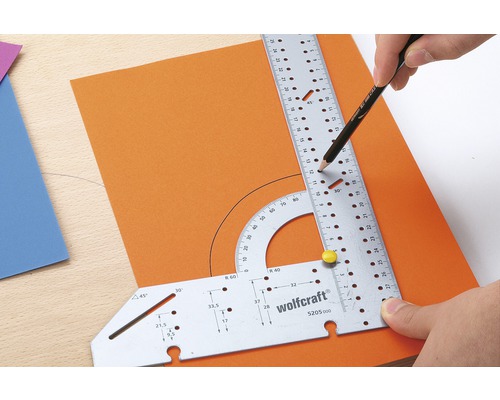 Équerre multifonctionnelle Wolfcraft pour dessiner un demi-cercle sur du papier orange avec un crayon.