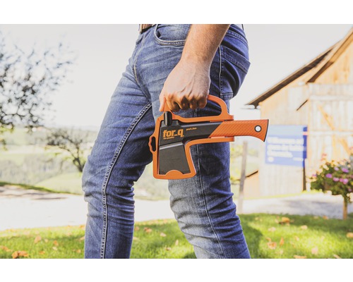 Une personne tient une hache de la marque For_q dans sa main.