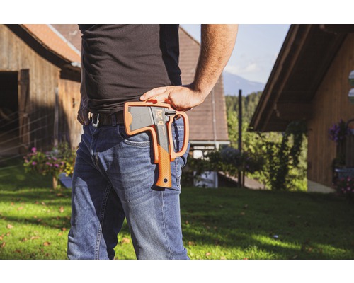 Personne avec une hache dans un étui à la ceinture en extérieur.