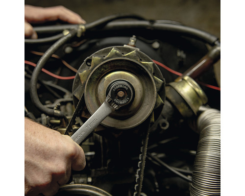 Une clé de 19 millimètres est utilisée sur un moteur de voiture.