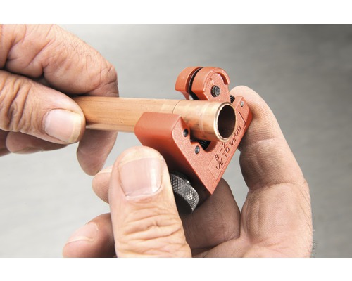 Coupe-tube en cours d''utilisation sur un tuyau de cuivre