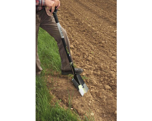 Eine Person benutzt einen Spaten im Garten.