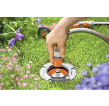 Scène de jardin avec prise d''eau enterrée et tuyau d''arrosage raccordé pour l''irrigation