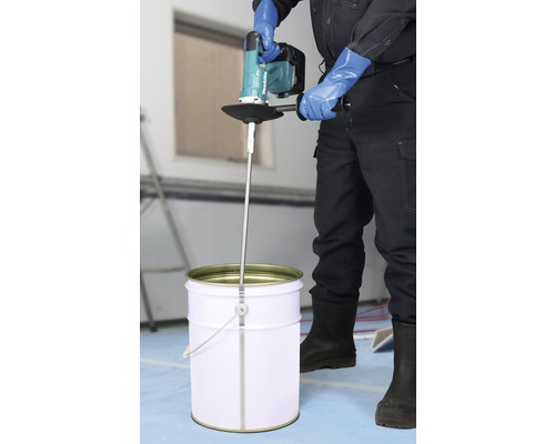 Handwerker mischt Material mit einem Farbmischer von Makita in einem Eimer.