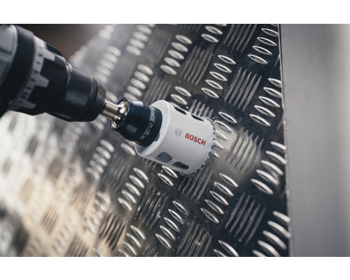 Bohrmaschine mit Bosch Logo beim Bohren eines Lochs in eine Metalloberfläche