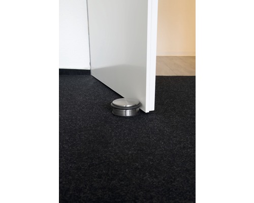 Butée de porte en métal sur le sol à côté d''une porte