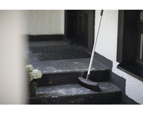 Balai sur un escalier devant une porte d''entrée
