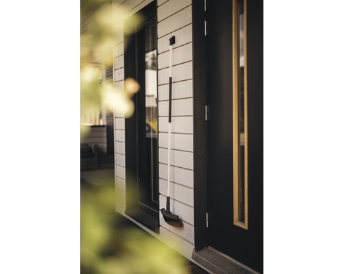 Balai de rue sur le mur de la maison à côté de la porte et de la fenêtre