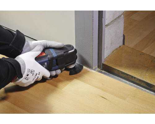 Outil électrique oscillant en cours d''utilisation sur un plancher en bois