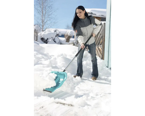 Femme déblaie la neige avec une pelle à neige