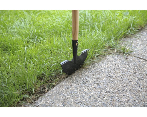 Coup bordure avec manche en bois et lame en acier dans la pelouse