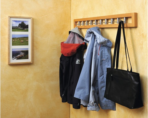 Porte-manteau avec vestes et sac sur un mur avec cadre photo