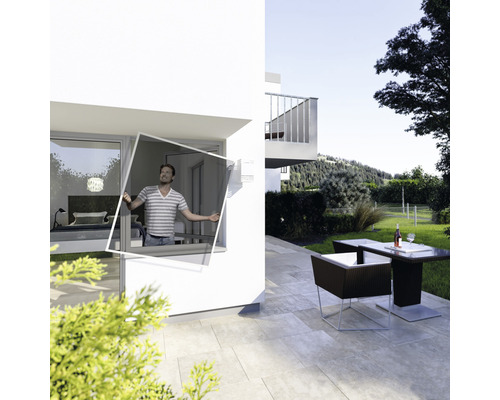 Homme installant une moustiquaire à la fenêtre d''une maison moderne avec terrasse