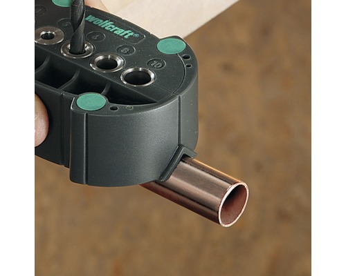 Logo Wolfcraft. Gabarit de perçage pour tuyaux lors du perçage.