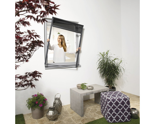 Scène extérieure avec moustiquaire pour fenêtres et une femme qui la tient