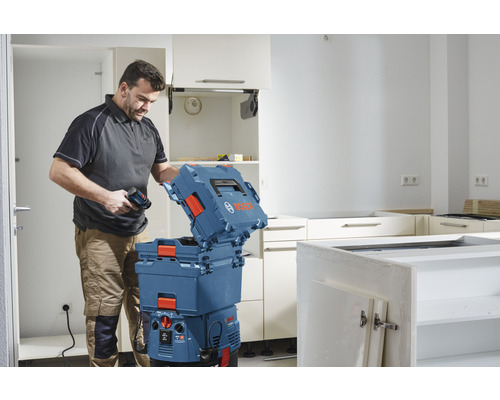 Artisan avec visseuse sans fil et coffret à outils dans la cuisine