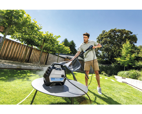 Mann reinigt Gartenmöbel mit einem Gloria Hochdruckreiniger im Freien