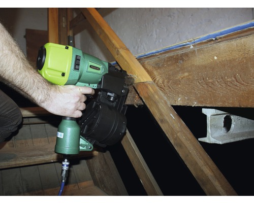 Eine Person verwendet einen Druckluftnagler, um Holz zu befestigen.