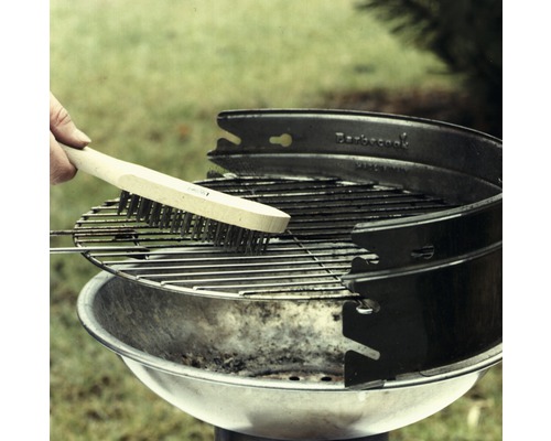 Brosse à gril nettoyant une grille de barbecue