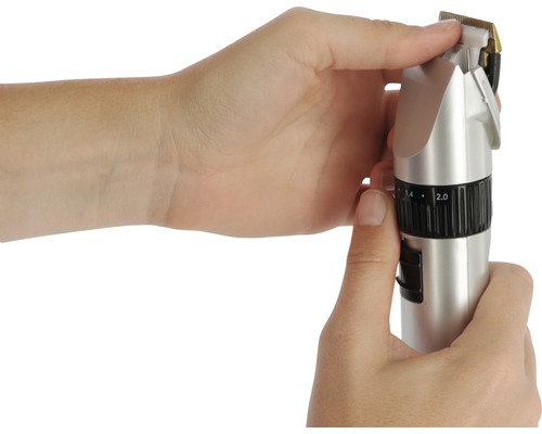 Les mains règlent une tondeuse à cheveux