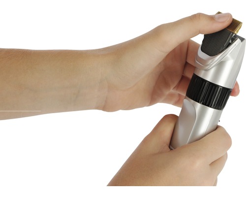 Mains manipulant une tondeuse à cheveux