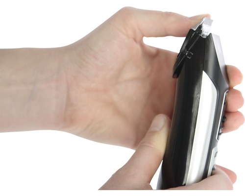 Main tenant une tondeuse à cheveux