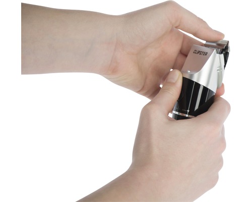 Une personne change la tête de rasoir d''une tondeuse à cheveux.