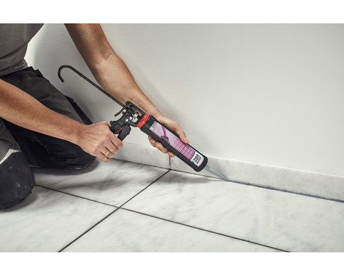 Jointoiement au pistolet à cartouche entre le mur et les carreaux de sol