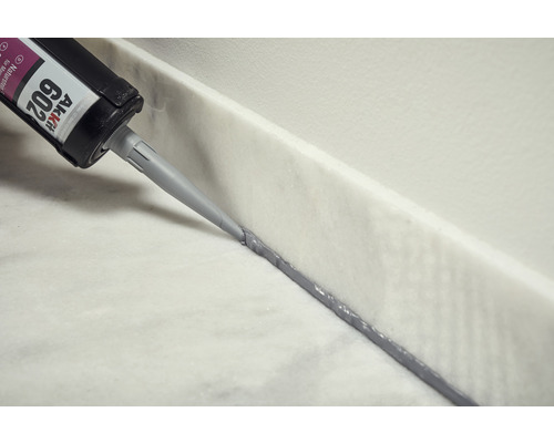 Application de silicone pour pierre naturelle avec une cartouche sur une surface en marbre.