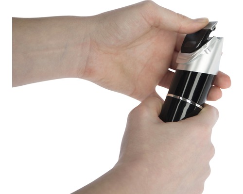 Mains manipulant une tondeuse à cheveux