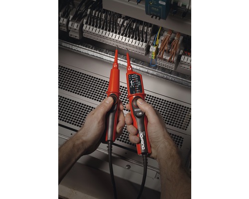 Un électricien teste un système électrique avec un testeur de tension bipolaire.