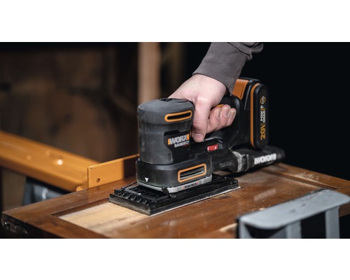 Ponceuse sans fil ponçant une surface en bois