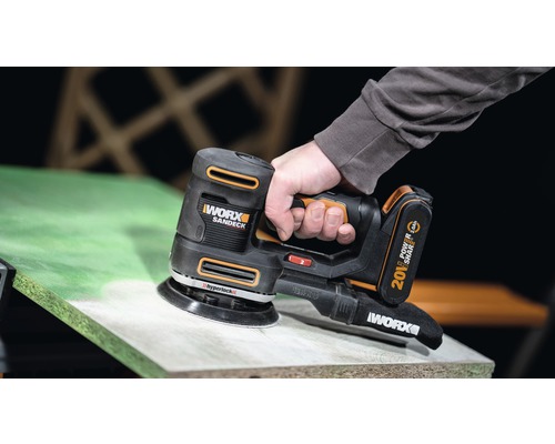 Ponceuse sans fil en cours d''utilisation sur une surface en bois.