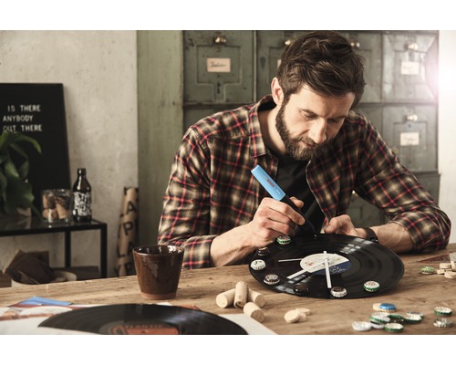 Un homme fabrique une horloge à partir d''un disque vinyle avec un stylo.