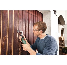 Mann arbeitet mit Multischleifer an einer Holztür.