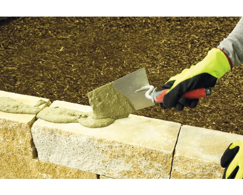 Construction d''un mur avec des pierres et du mortier à la truelle