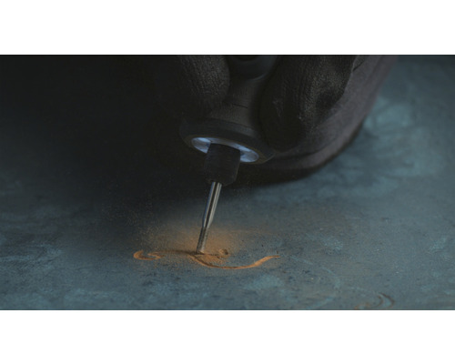 Une personne grave avec un outil multifonctionnel dans un matériau.