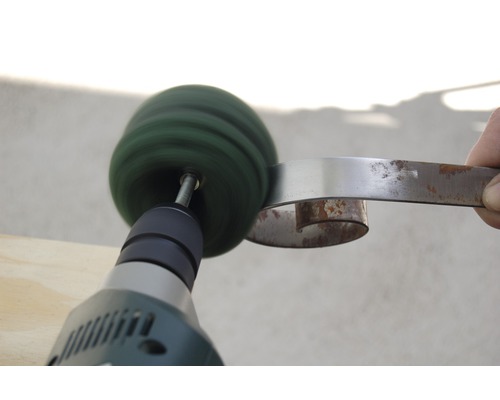 Bohrmaschine mit Polierscheibe reinigt Metall