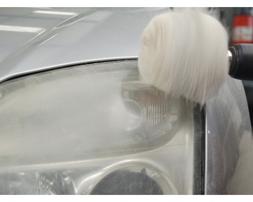 Scheinwerferaufbereitung mit Polieraufsatz an Auto