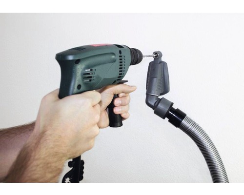 Perceuse à main avec accessoire aspirateur en cours d''utilisation