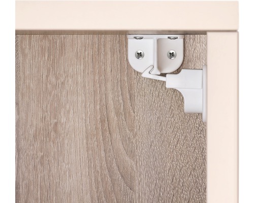 Loquet de meuble blanc fixé sur une armoire en bois