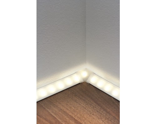 Eckansicht eines Raumes mit LED-Leiste zwischen Wand und Holzboden