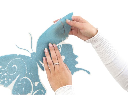 Application d''un sticker mural avec un motif de papillon