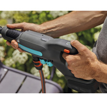 Eine Person bedient eine Gardena Gartendusche mit Akku